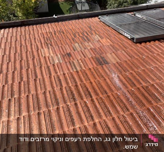 גג רעפים אדומים עם לוחות סולאריים
